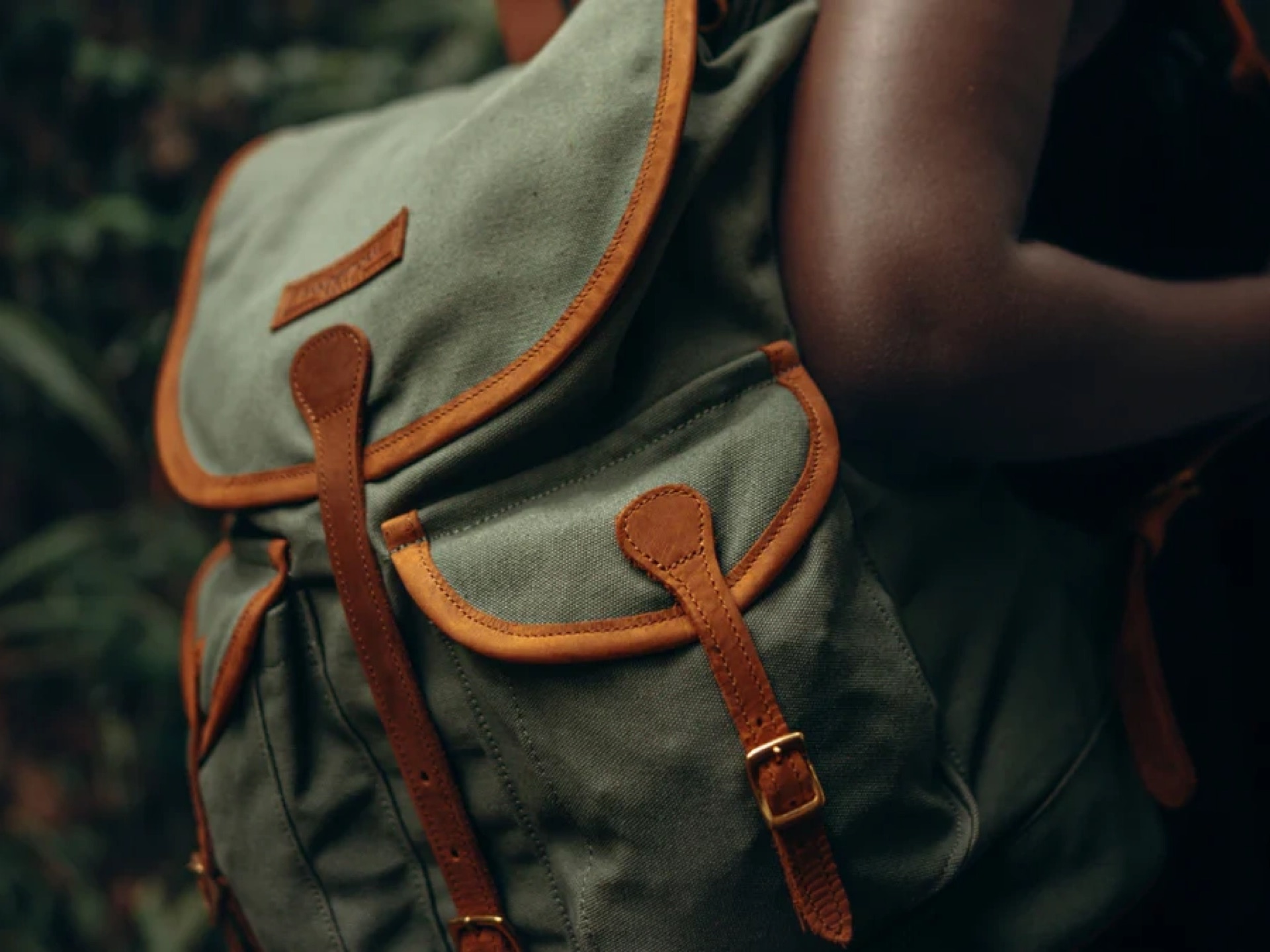 A canvas and leather rucksack carried on someone’s shoulder